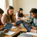 Une enseignante et des élèves de collège analysent ensemble des visualisations abstraites d’une réponse d’intelligence artificielle sur des tablettes, dans une salle de classe studieuse et bienveillante.
